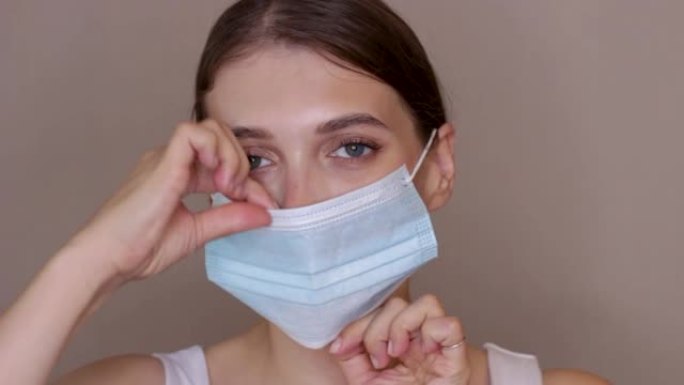 一个女孩在脸上戴上医用口罩的肖像特写。