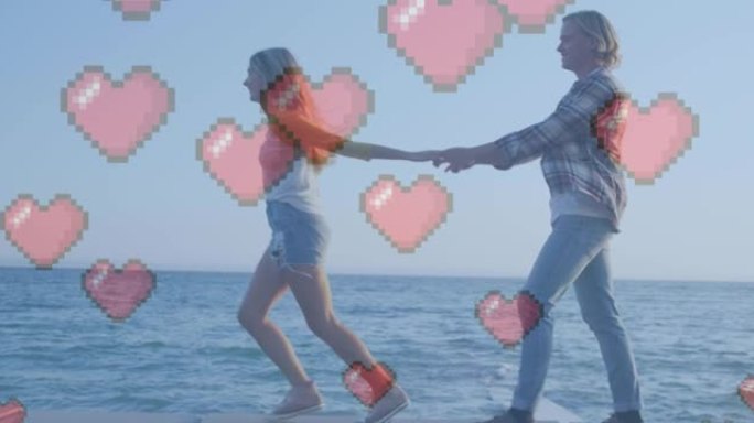 多个红色的心脏图标漂浮在白人夫妇手牵着手走在海边