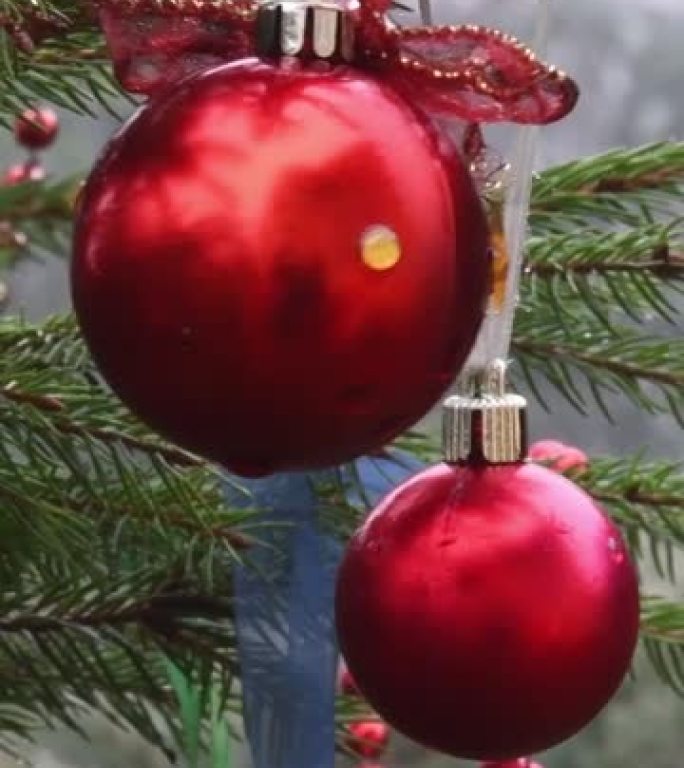 挂在户外圣诞树冷杉树枝上的红色圣诞球