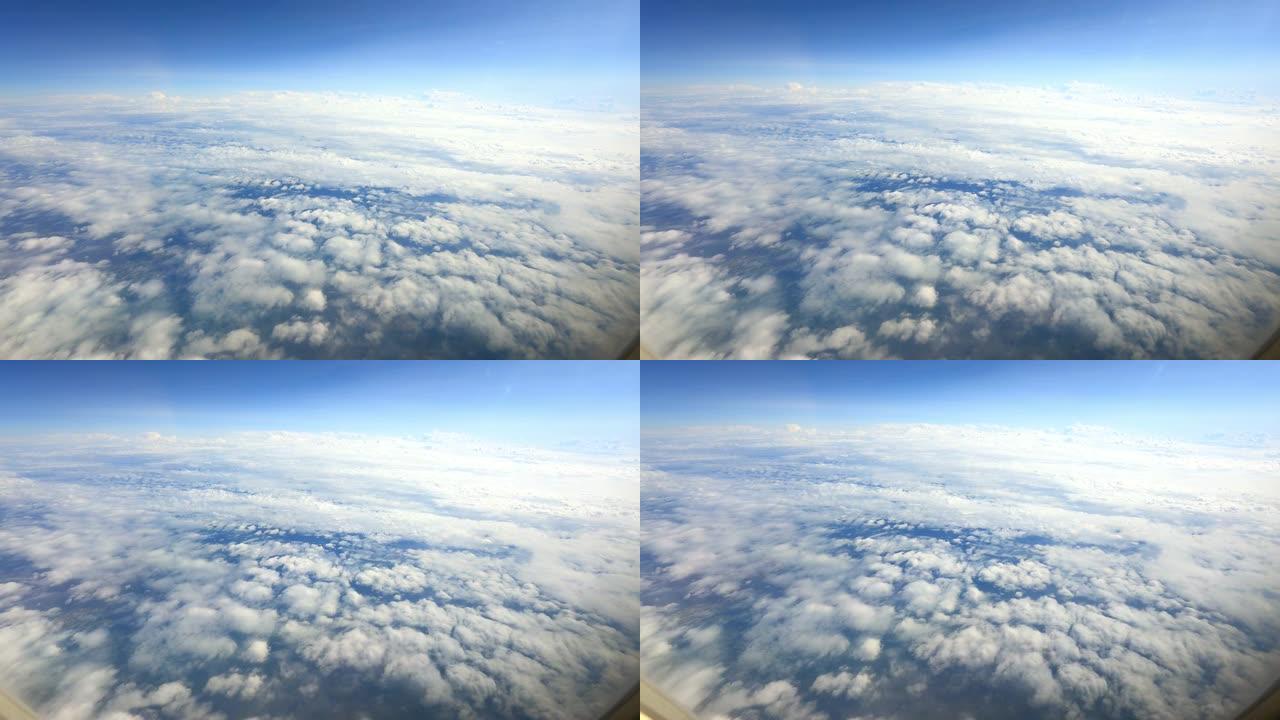 穿过飞机窗户的地面上布满云层的奇妙太空景观