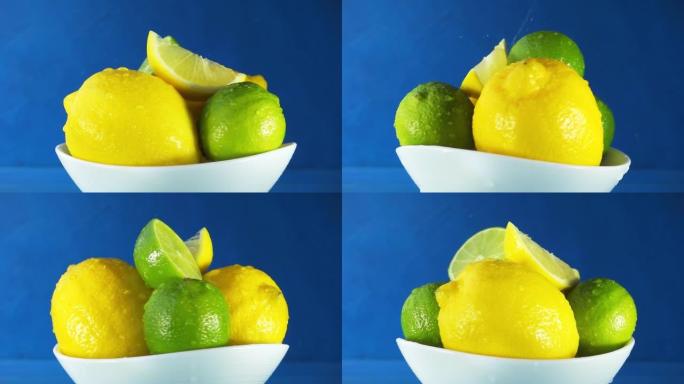 整个和切成薄片的柠檬和酸橙在白色的盘子特写镜头中，水花在蓝色的背景上旋转。4k慢动作视频。