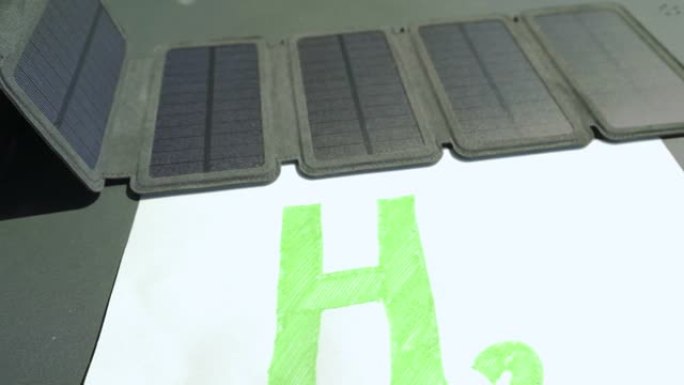 绿色氢概念。太阳能电池板连接到H2文本，象征没有化石燃料的太阳能产生氢气。