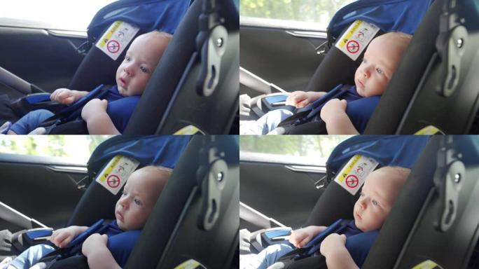 面对三个月大的男婴在汽车上的婴儿座椅，婴儿在汽车上旅行。