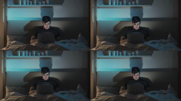 夜间在线工作疲倦的人在床上使用笔记本电脑