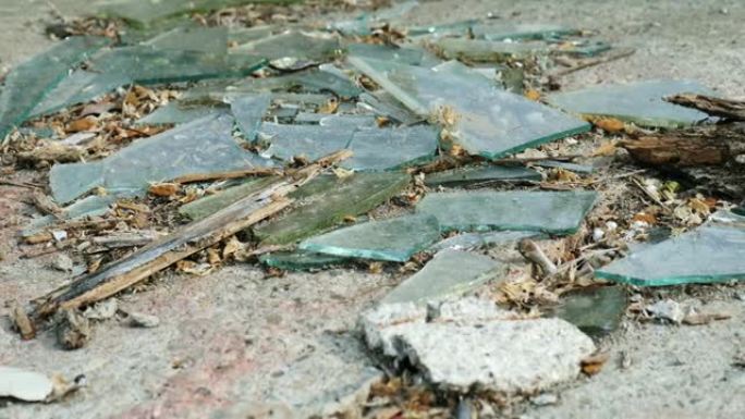 锋利的玻璃碎片在户外用木头碎片躺在地面上