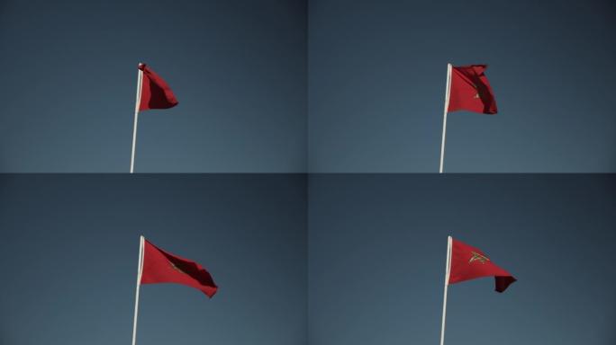 旗杆上随风飘扬的国旗。绿色交错的五角红旗。对抗晴朗天空的国家符号。摩洛哥、非洲