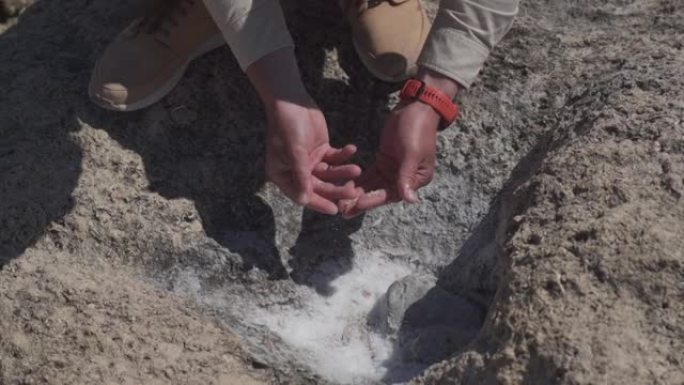 男性地质学家检查了来自海洋附近岩石的晶体海盐样本。海洋地质学家检查了岩石地区从海中蒸发的矿物样品。地