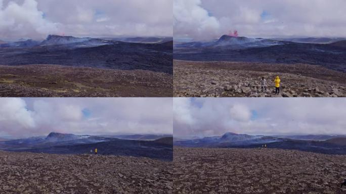 两名冒险旅行者的无人机拍摄从远处观看一座喷发的火山