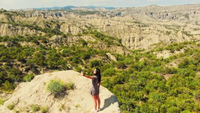 空中缩小视野漂亮女人游客在夏天的假日假期在明亮的灯光下在风景优美的地方自拍。航空摄影旅行冒险概念。