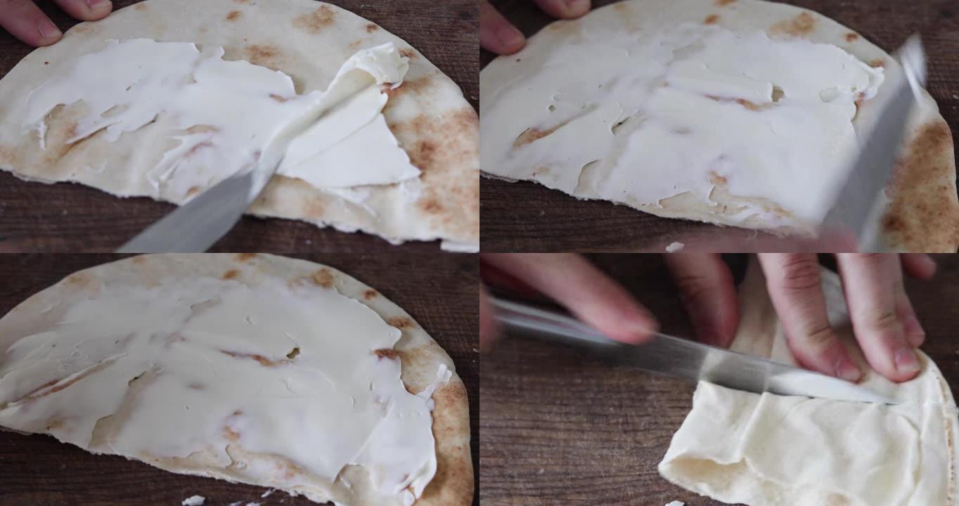 用刀将马斯卡彭切片涂在薄的新鲜皮塔饼上，然后切开