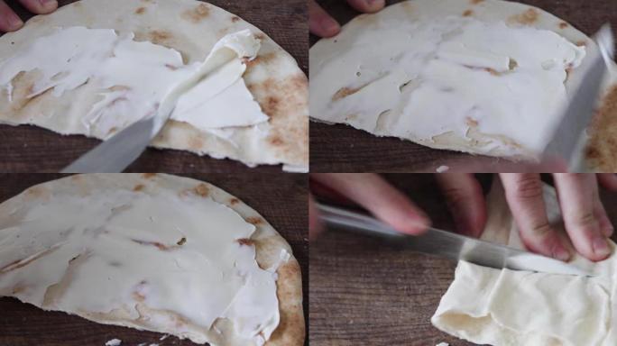 用刀将马斯卡彭切片涂在薄的新鲜皮塔饼上，然后切开