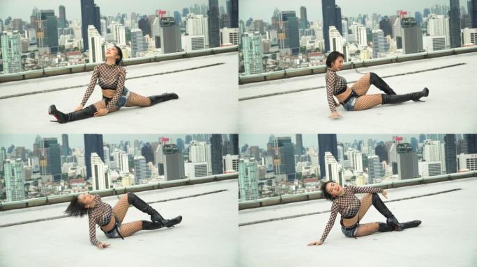 年轻的亚洲女舞者在城市景观背景下练习在屋顶上跳舞。艺术家在摩天大楼表演中跳舞k-pop女团