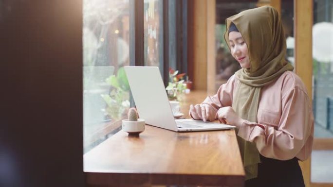在咖啡店工作的年轻亚洲穆斯林妇女