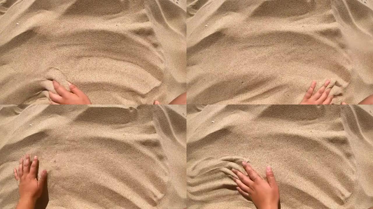 人将手放在黄沙表面，用手指将其散射。