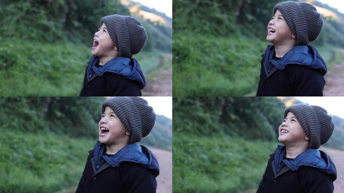 亚洲男孩戴着毛线帽，在冬季大笑