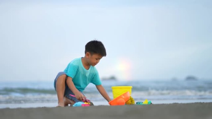 亚洲孩子在海滩玩沙堡