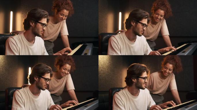 年轻有魅力的音乐家在钢琴键盘上录制歌曲，为新的音乐专辑在现代工作室合作