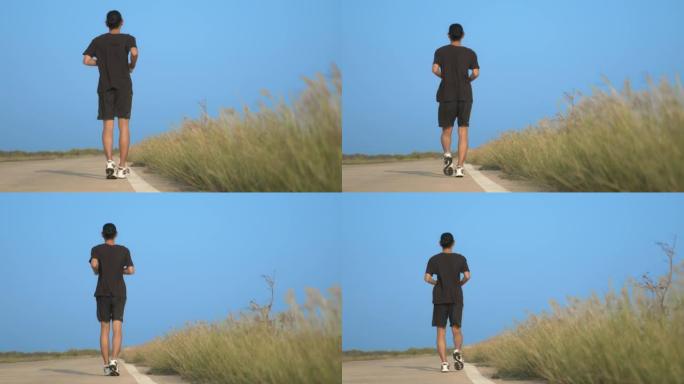 亚洲男子在公路上跑步冲刺。在户外锻炼和锻炼中适合男性健身运动员