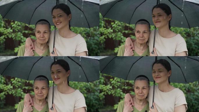 雨中的老人和年轻妇女在伞下