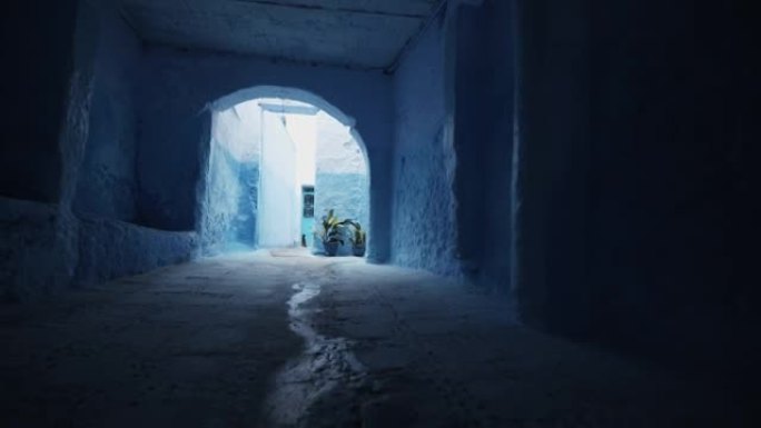 蓝色城市Chefchaouen的小巷和后院的前锋揭示。穿过房子下面长长的黑暗走廊。摩洛哥、非洲