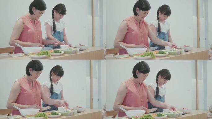 孩子在母亲的帮助下在家做寿司来学习烹饪