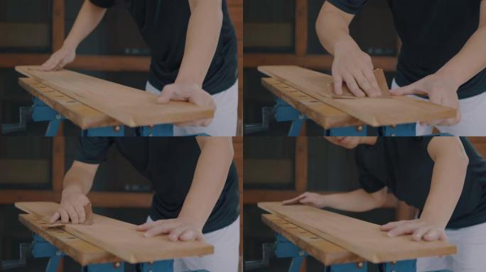 亚洲男木匠打磨木板。th