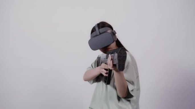 戴着玩具武器的虚拟现实眼镜的亚洲女孩在5D景点玩耍