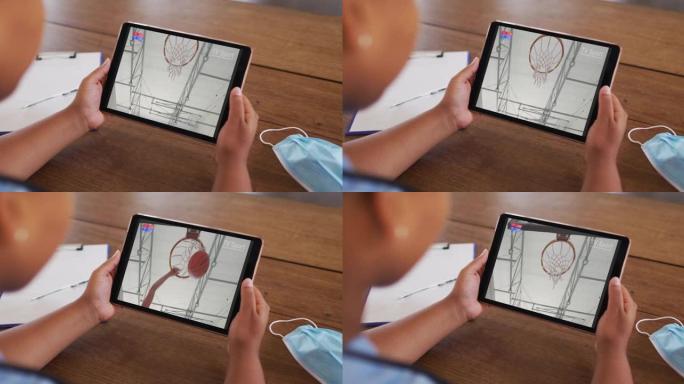 女人坐在桌子上戴着口罩，在平板电脑上观看篮球比赛的复合材料
