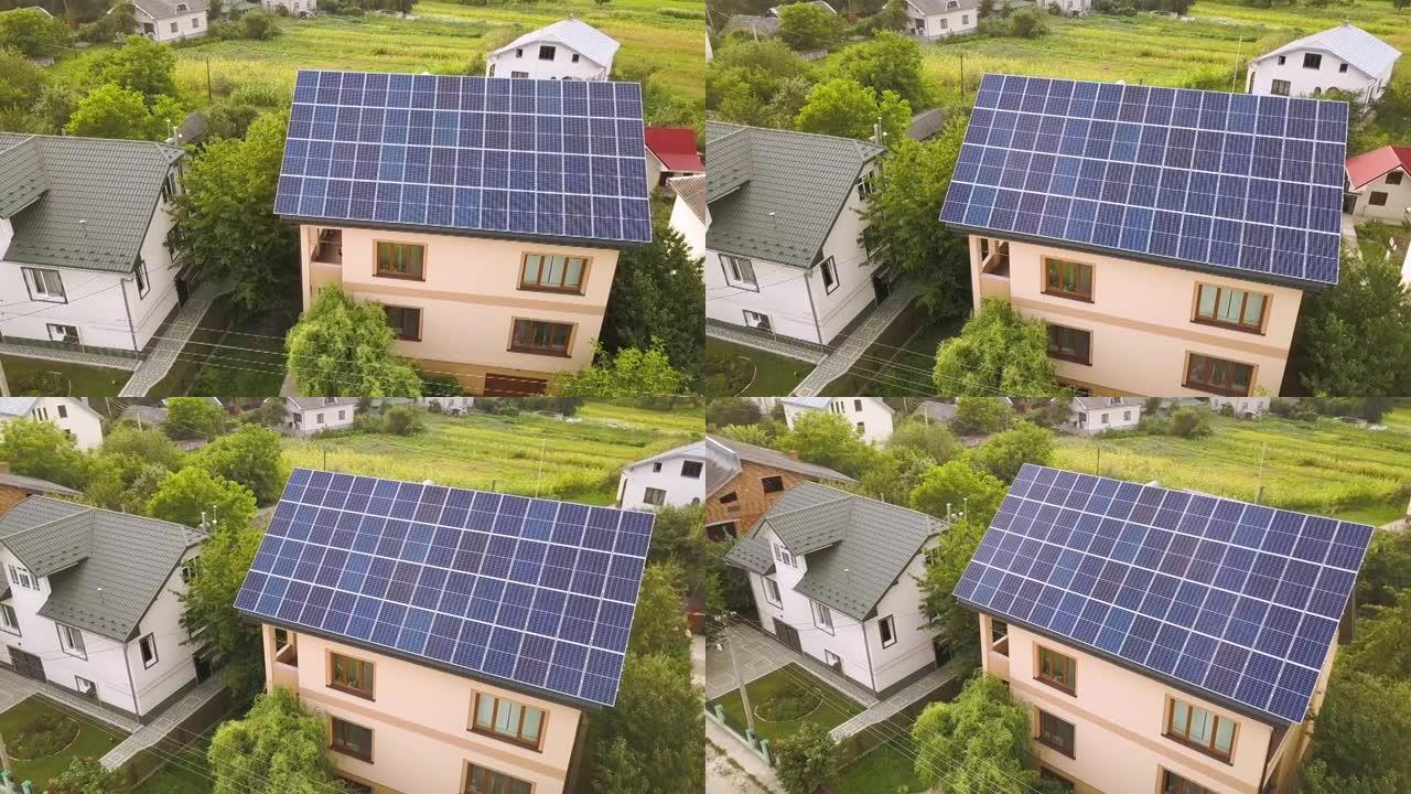 新的现代住宅小屋的空中俯视图，屋顶上有蓝色闪亮的太阳能光伏面板系统。可再生生态绿色能源生产理念。