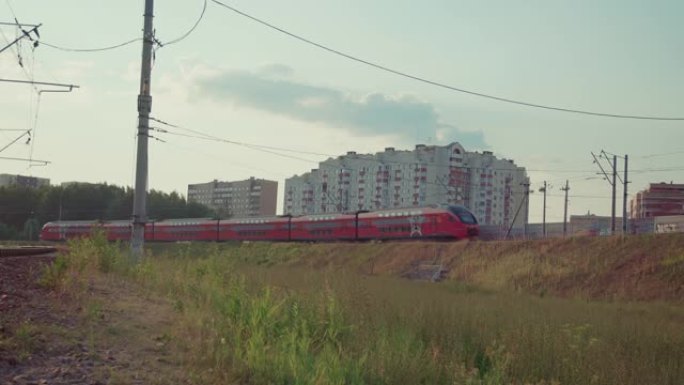 红色双层火车驶过多层住宅楼