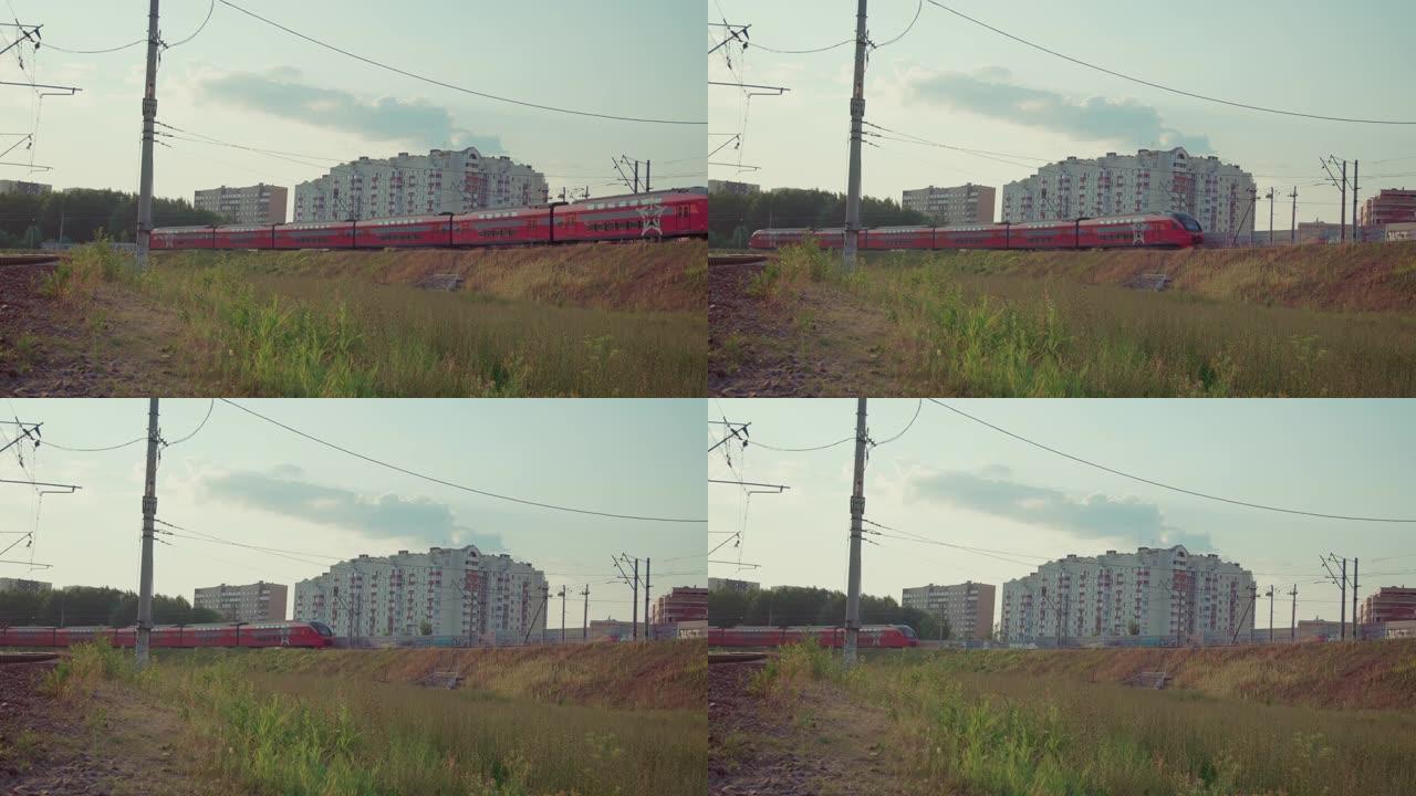 红色双层火车驶过多层住宅楼