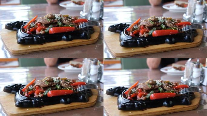 糖醋肉和蔬菜。在铸铁锅上炒肉和蔬菜和芝麻。正宗的食物概念。