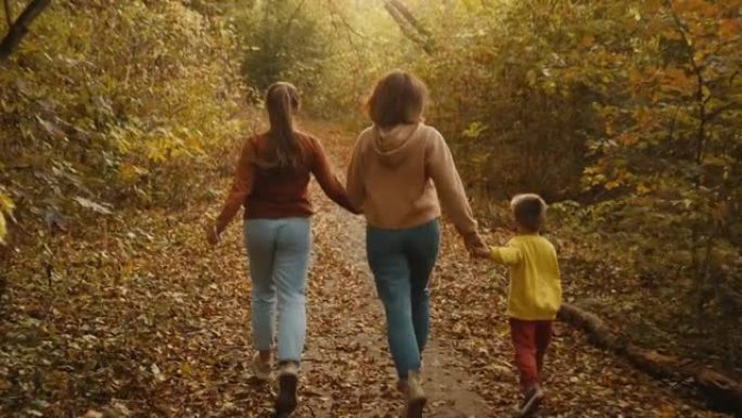 妈妈和孩子们在秋天的森林中奔跑