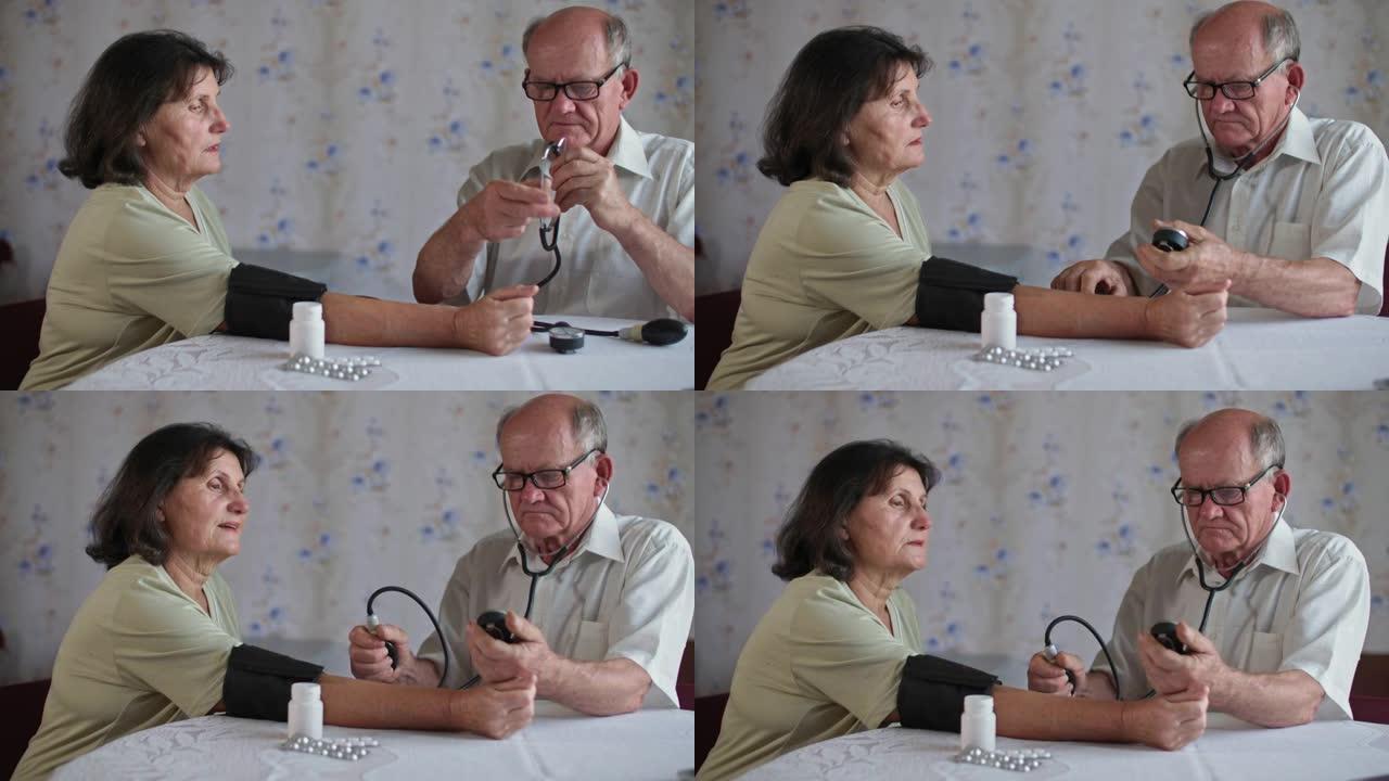 健康退休，有爱心的戴眼镜的老人用眼压计在家中坐在餐桌上的眼压计测量妻子的压力