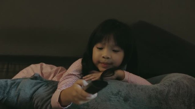 可爱的亚洲女儿在家看电视时换频道-股票视频