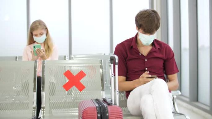 旅客在机场等候离港航班时戴防护面罩