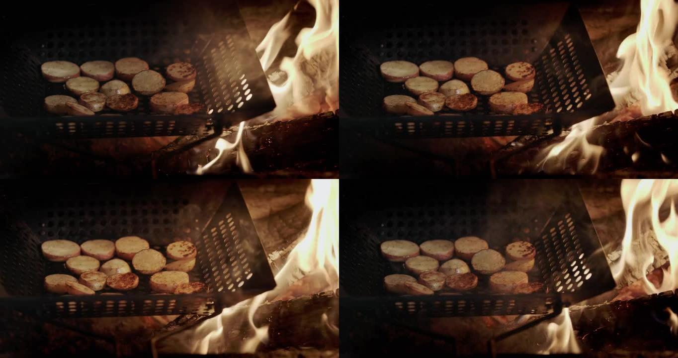 将土豆片在烤架的煎锅中油炸，在煎锅火焰和热煤旁边