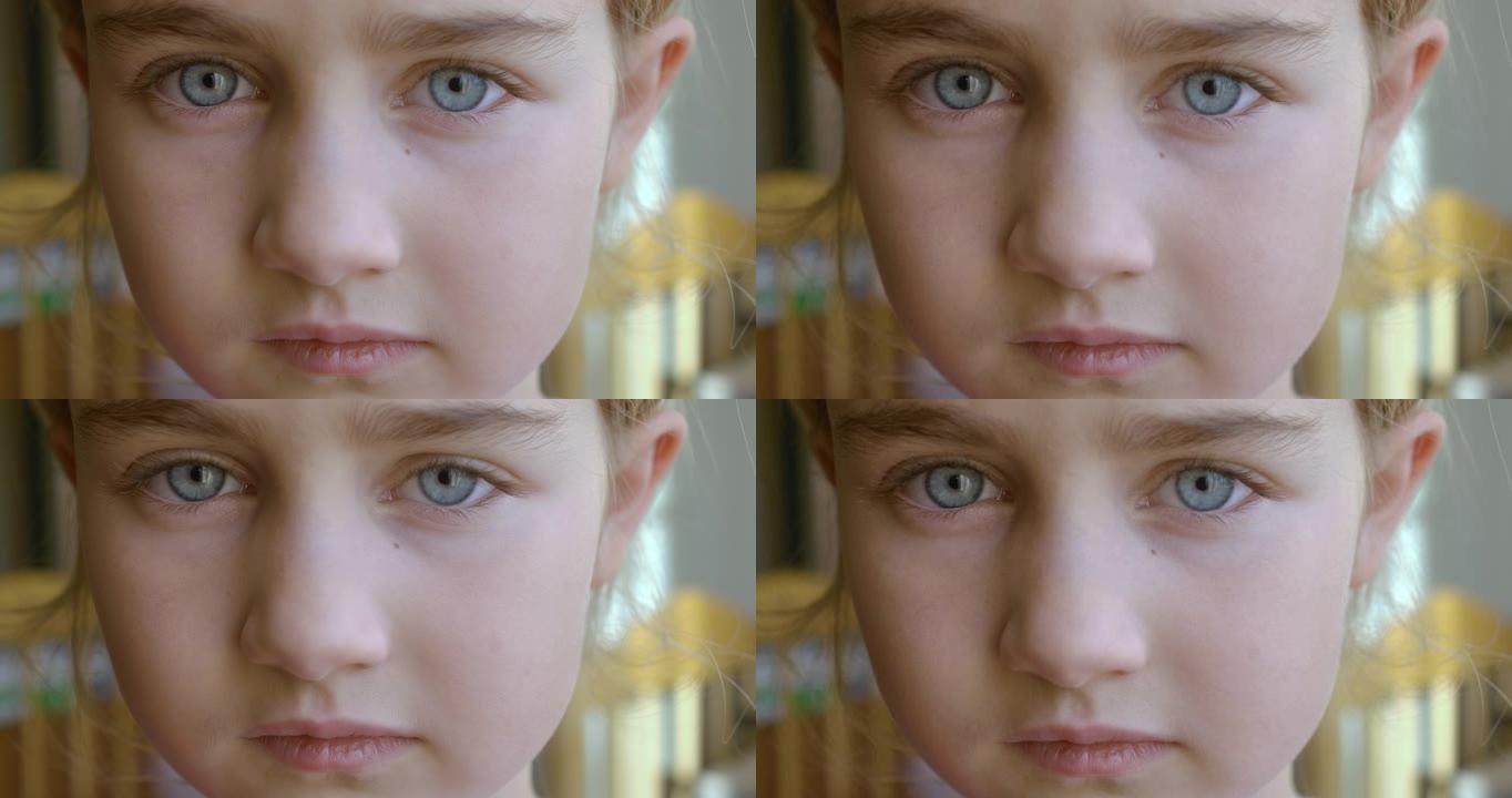蓝色眼睛看着相机的肖像小女孩。年轻悲伤的好奇心孩子在户外看着相机特写。面对严肃沉思的孩子。