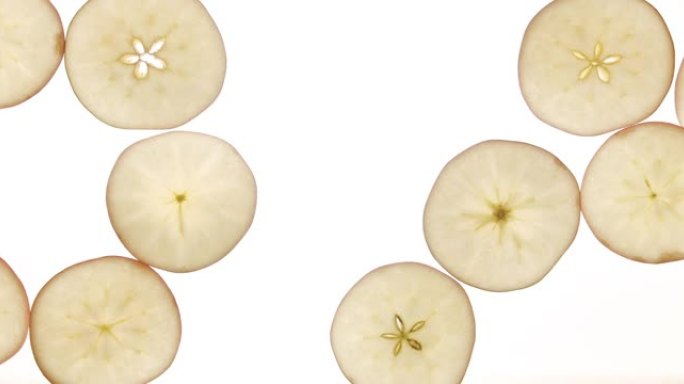 水果新鲜苹果片在俯视图中，它们一个接一个地出现在商业果汁中