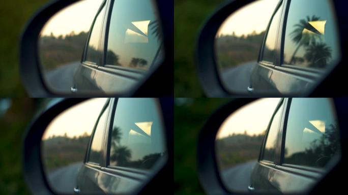 在印度拉贾斯坦邦乌代布尔的日落期间，从高速公路上的侧视镜上看到的汽车特写镜头