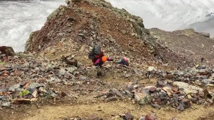 一位疲倦的游客沿着一条山路跌跌撞撞地走过石头和巨石。