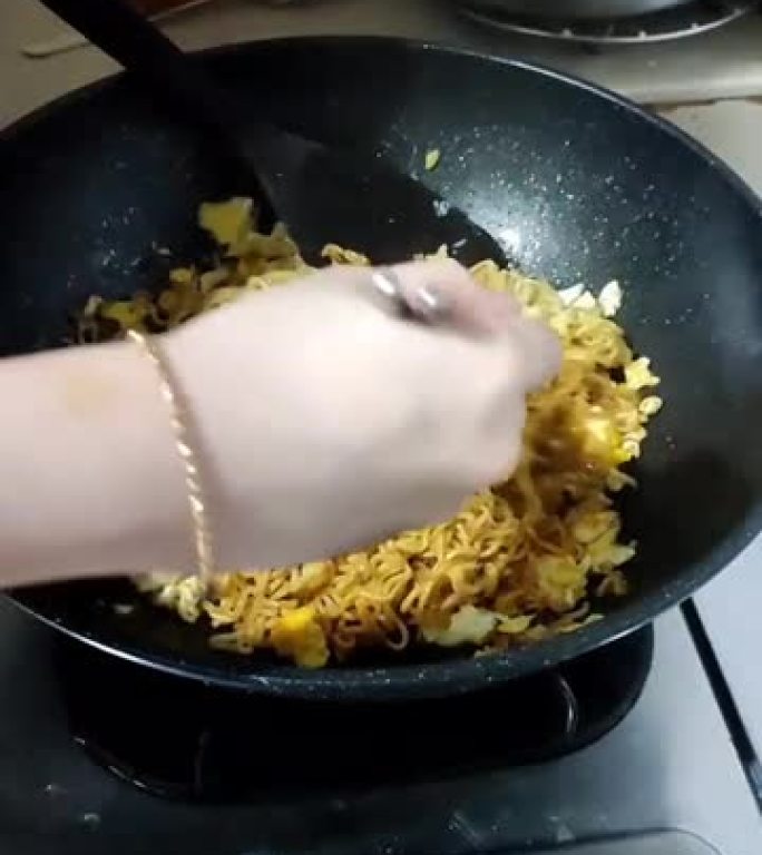 家中厨房烹制即食炒面的过程。用煎蛋煮的面条。