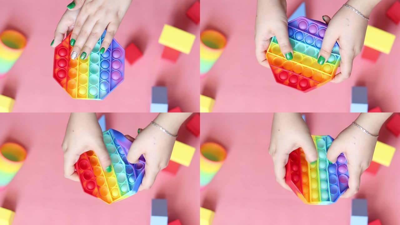 流行的popit硅胶玩具，女孩玩鲜艳的彩色抗压玩具。波普。精细运动技能的发展