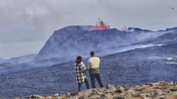 旅行者站在岩石田和火山爆发的景观上
