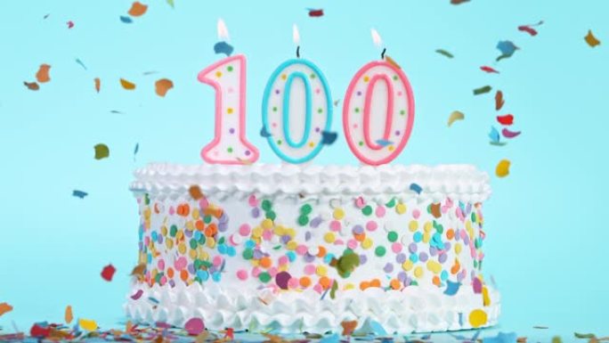 生日蛋糕与燃烧五颜六色的蜡烛与数字100