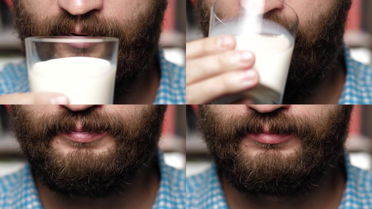 大胡子的人正在喝牛奶。男性的手将玻璃举到嘴里，喝牛奶。特写