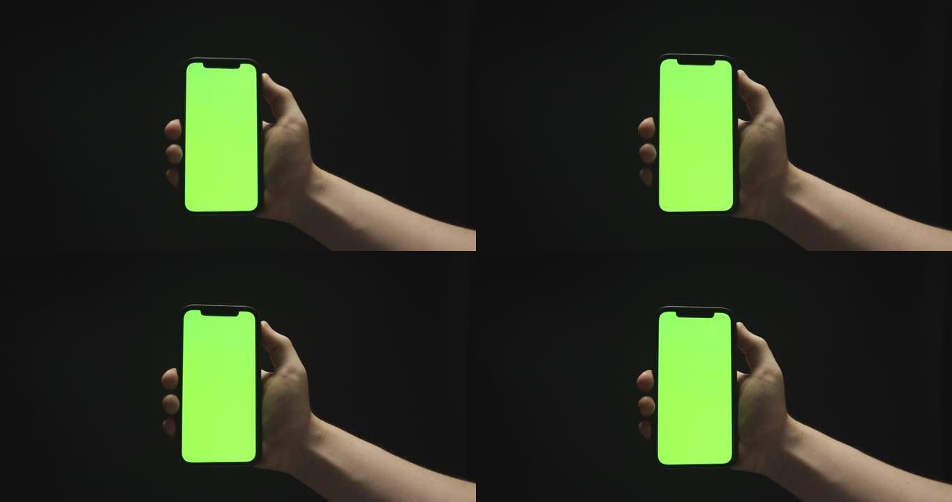 拾起并放下黑色背景的绿屏智能手机