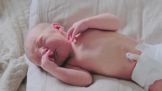 新生儿躺在床上哭，特写镜头