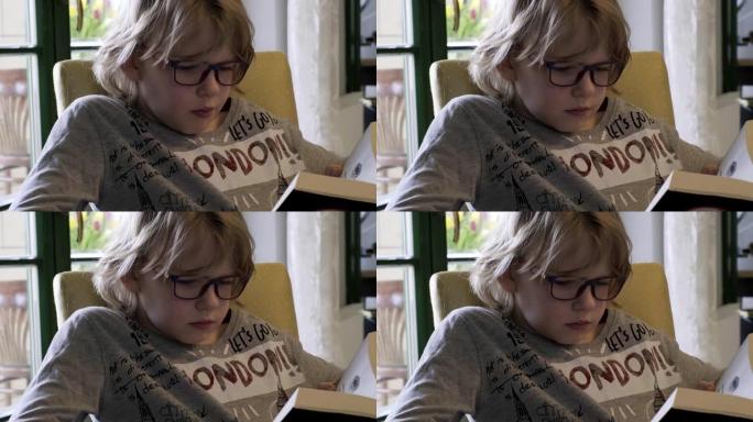 戴着眼镜看书的小男孩。