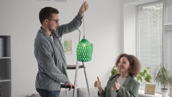 家装，有才华的男人和女人在家里悬挂3D打印机上打印的原型灯罩